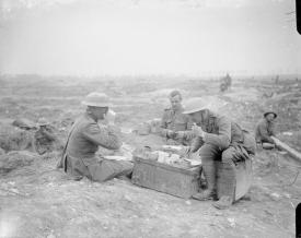 Officers dining. One is wearing a private's uniform. Near Bernafay Wood, July 1916 © IWM (Q 4053)